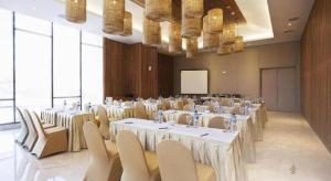 a conference room with tables and chairs and a screen at The Rinra in Tanjungbunga +154 photos