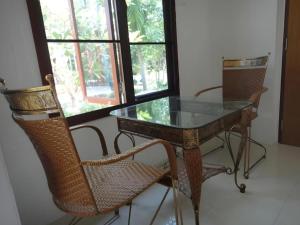 une table et des chaises en verre dans une chambre avec fenêtre dans l'établissement Rai Sai Luang Resort, à Ban Na Khwai