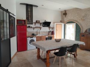 a kitchen with a table and a red refrigerator at Maison de style La Grange in Asquins