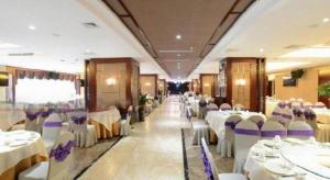 DianbailiaoにあるManhatton Hotel Beihaiの白いテーブルと紫色の椅子が備わる宴会場
