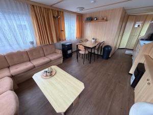 a living room with a couch and a table at Camping Noetselerberg - Sallandse Stee - Stacaravan 5pers in Nijverdal