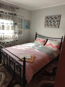a bedroom with a bed with pink sheets and a window at Villa Sofia By The Sea in Leptokaria