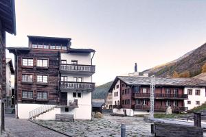 a group of buildings with mountains in the background at Alpenblick Apartment in Saas-Grund
