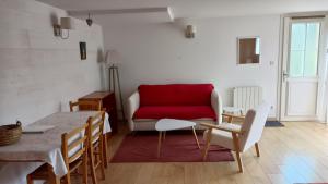 a living room with a red couch and a table at Chambre d'hôte l'Olivier in Charly +8 photos