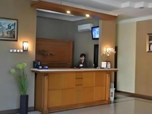 un homme assis au comptoir dans une salle d'attente dans l'établissement Hotel Khalista, à Gurungsang