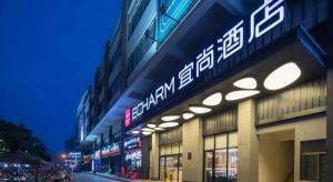 a building with a sign on the side of it at Echarm Hotel Danzhou Xiari Plaza in Danzhou