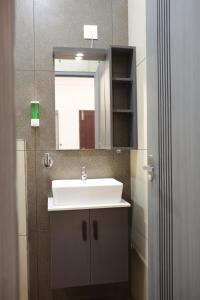 a bathroom with a white sink and a mirror at Venetus Beach Residence in Varkala