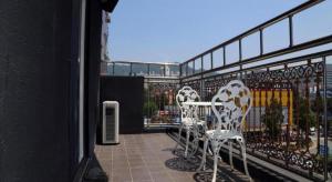 three white chairs sitting on a balcony with a fence at Cinema Motel in Daejeon