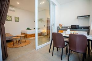 a room with a table and chairs and a bed at Bali Bay by Urban Haven in Sanur