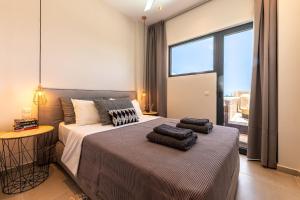 a bedroom with two beds and a large window at 2br Suite White gea with private pool no01 in Vassilias +18 photos
