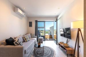 a living room with a couch and a tv at 2br Suite White gea with private pool no01 in Vassilias
