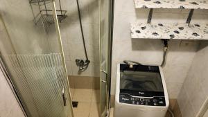 une petite salle de bain avec toilettes et douche dans l'établissement Monitor Gear Residences, à Manille