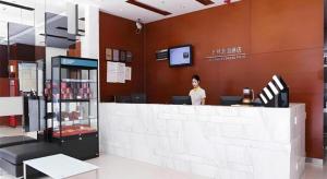 a woman standing at the counter of a store at City Comfort Inn Nanning Shanglin Longhu Road in Shanglin