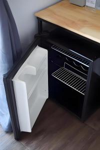 Un refrigerador con la puerta abierta al lado de un mostrador. en X GO INN Chiang Mai University - CMU, en Chiang Mai