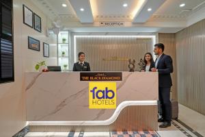 Un grupo de personas de pie en una mesa en un vestíbulo. en FabHotel The Black Diamond - Tavarekere, behind Forum Mall, Koramangala, en Bangalore