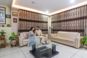 a man and a woman sitting in a living room at FabHotel Keerthi's Anupama - Nr Indira Gandhi Stadium in Vijayawāda