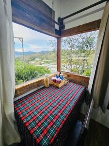 a bed in a room with a large window at NOMAD Home & Coffee in Da Lat