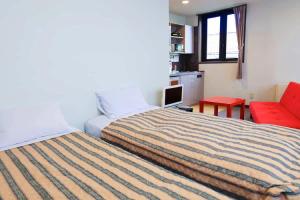 a hotel room with a bed and a red couch at コンドミニアム白馬五竜 in Hakuba