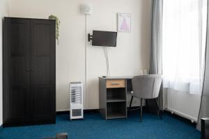 a room with a desk with a computer and a chair at Hotel CB Royal in České Budějovice