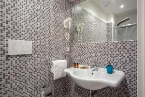 y baño con lavabo y espejo. en Frattina Grand Suite Guesthouse, en Roma