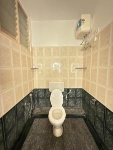 a bathroom with a toilet and a air conditioner at The Maanvik Shores Luxury Home Stay - RK Beach in Visakhapatnam
