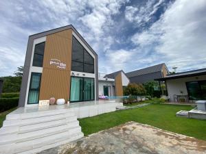 a house with a sign on the side of it at Poolla Poolla Villa Khaoyai in Pak Chong