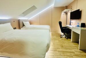 a hotel room with two beds and a desk at KIMMIY Garni Attic Rooms near Belgrade Airport in Beograd