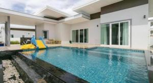 a swimming pool in the middle of a house at Capital O 1009 Leleaf Valley Pool Villa Resort Hua Hin in Hua Hin