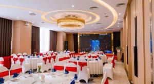 a banquet hall with white tables and red and white chairs at Khach san Toan Thang Stone in Lóc Ða +201 photos