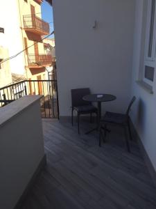 カステッランマーレ・デル・ゴルフォにあるTeorema Holiday Houseのバルコニー付きの客室で、小さなテーブルと椅子が備わります。