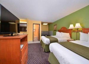 a hotel room with two beds and a flat screen tv at Quality Inn & Suites Grinnell near University in Grinnell +79 photos