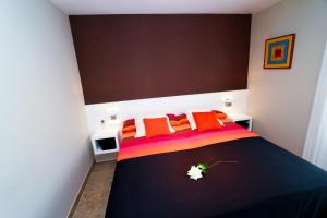 a bedroom with a black bed with orange pillows at Supreme Planet Costa Dorada in Cambrils