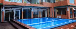 a swimming pool in front of a building at OYO 246 Roy Villa Beach Hotel in Paiyagala North