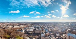 een luchtfoto van een stad onder een blauwe lucht bij Charmantes Appartement im 25 OG mit Aussicht und 60 Zoll TV in Augsburg +3 foto's