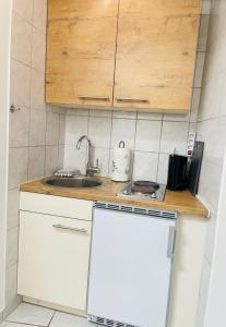 een keuken met een wastafel en een witte koelkast bij Charmantes Appartement im 25 OG mit Aussicht und 60 Zoll TV in Augsburg