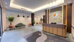Un vestíbulo de oficina con un mostrador de recepción y sillas. en Joya Hotel, en Phnom Penh