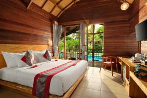 a bedroom with a large bed and a balcony at Nerissa 2 BR Dazzling Side By Side ZN332 in Gili Air