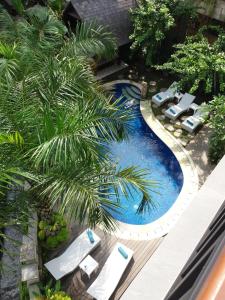 an overhead view of a swimming pool with cars and palm trees at Amoya Inn in Ubud