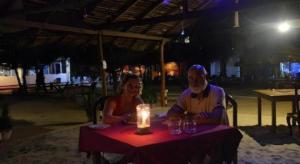 a man and a woman sitting at a table with a candle at Silver Beach Hotel in Trincomalee