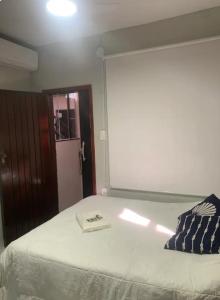 カボ・フリオにあるCantinho Submarino, aproximadamente 10 minutos caminhando até a praia do Forte, com Ar condicionadoの枕が置かれたベッドのある寝室