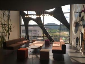 a waiting room with couches and tables and windows at KT&G Sangsangmadang Chuncheon Stay (Korea Quality) in Chuncheon