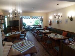 a restaurant with tables and chairs and a television at Gaestehaus-Staats in Obervellach