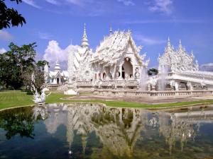 a white building with a reflection in the water at XX Stay On Maya Nimman - สเตย์ ออน เมญ่า นิมมาน in Chiang Mai