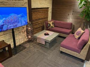 un salon avec deux canapés et une télévision à écran plat dans l'établissement Hotel Bougainvillea Akebonobashi, à Tokyo