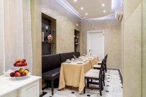 uma sala de jantar com uma mesa longa com cadeiras e frutas em Frattina Grand Suite Guesthouse em Roma