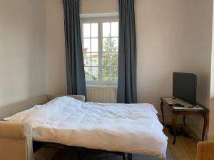 Un dormitorio con una cama y un escritorio con una computadora. en Maison Abbatucci, en Huningue