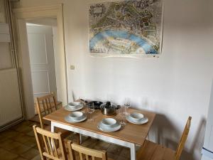 Una mesa de madera con platos y copas de vino encima. en Maison Abbatucci, en Huningue 8 fotos más