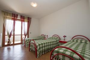 a room with four beds with green and white sheets at Vistamare in Martinsicuro