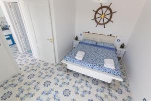 1 dormitorio con 1 cama con azulejos azules y blancos en Gyaaim, en Castro di Lecce