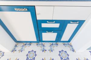 a blue and white kitchen with blue and white cabinets at Gyaaim in Castro di Lecce